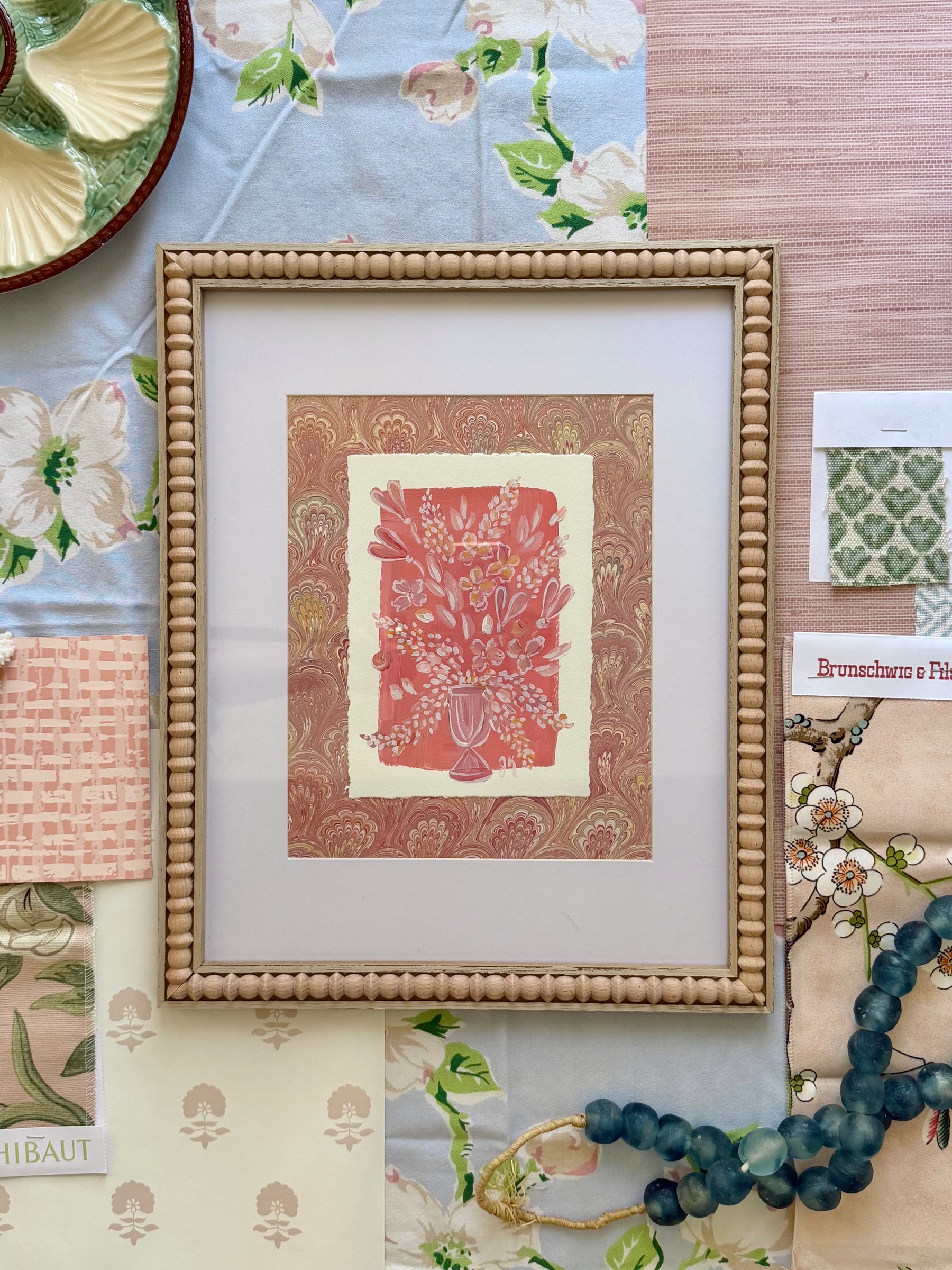 Framed artwork on a tablecloth with floral patterns